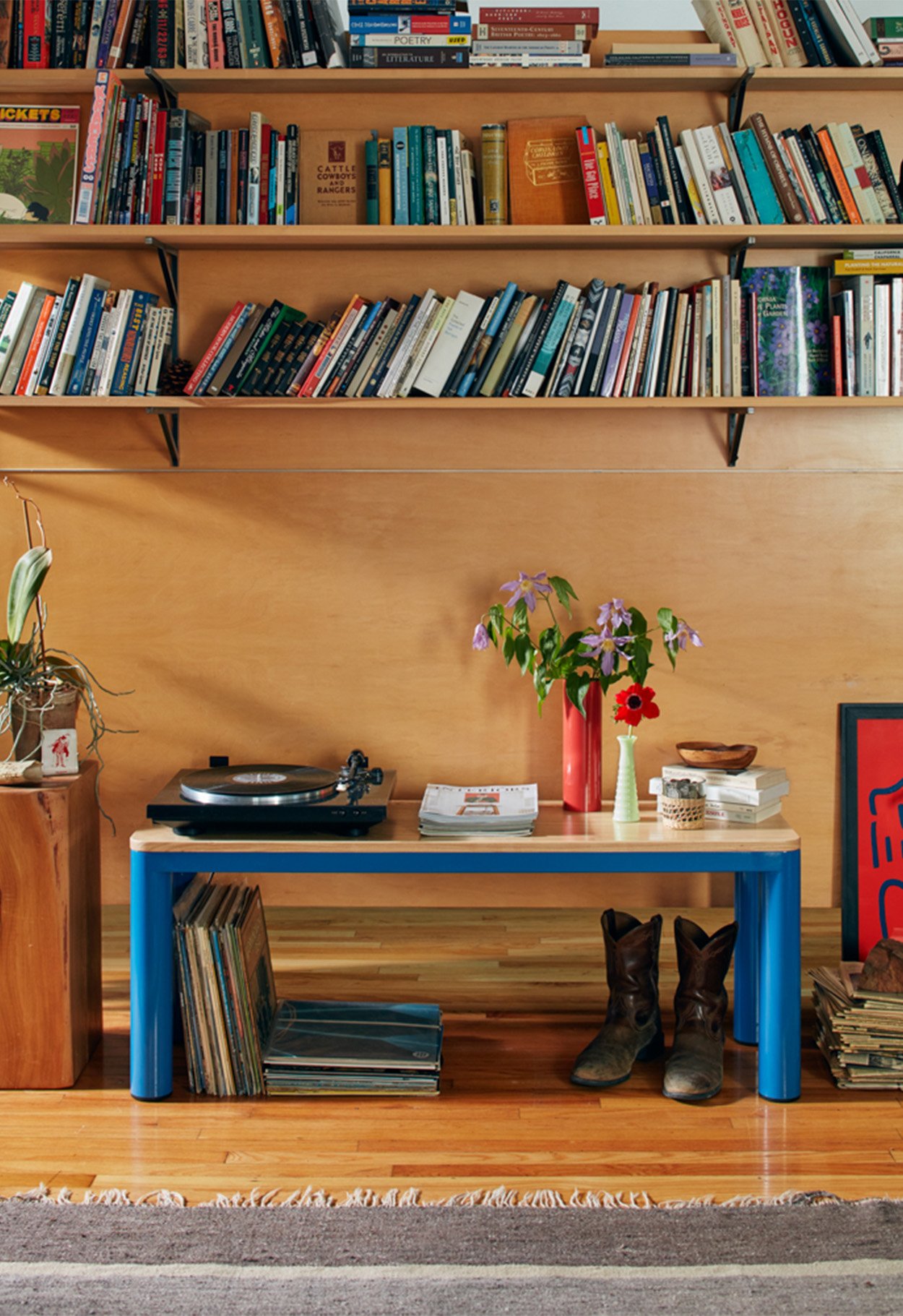 Bench with blue legs with record player and vases on table top
