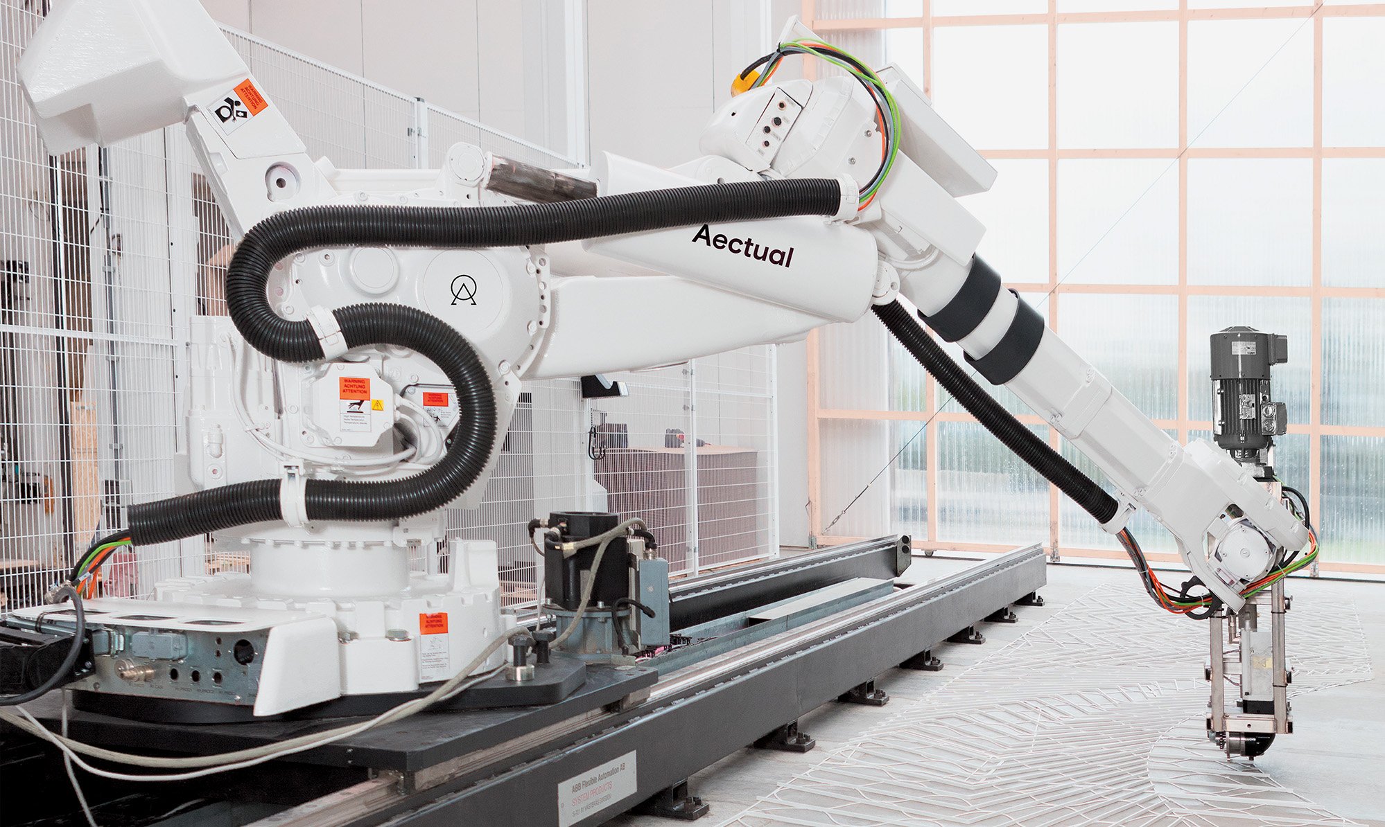 A robot machine printing a surface in white material.