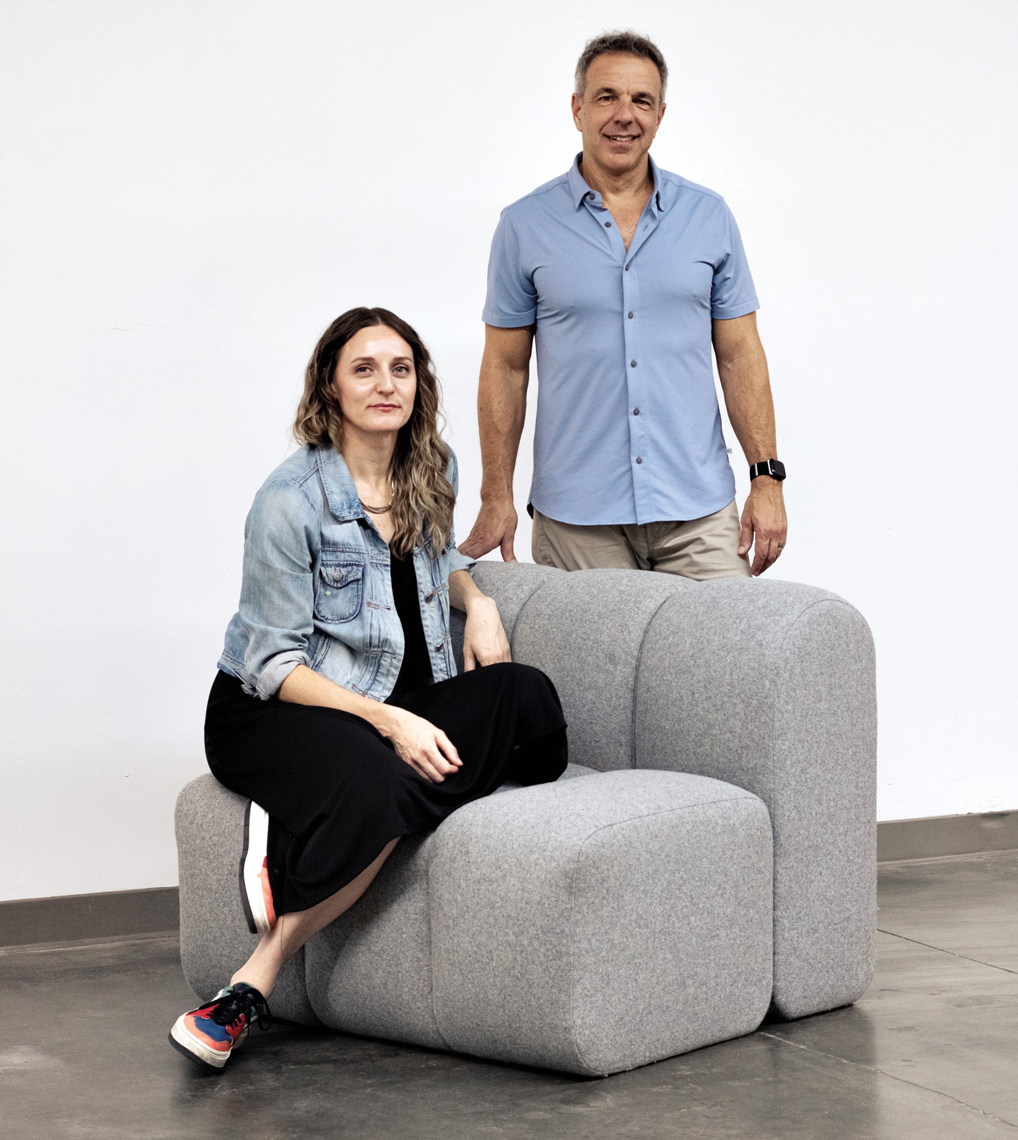 Owners of Emblem sitting on upholstered gray chair