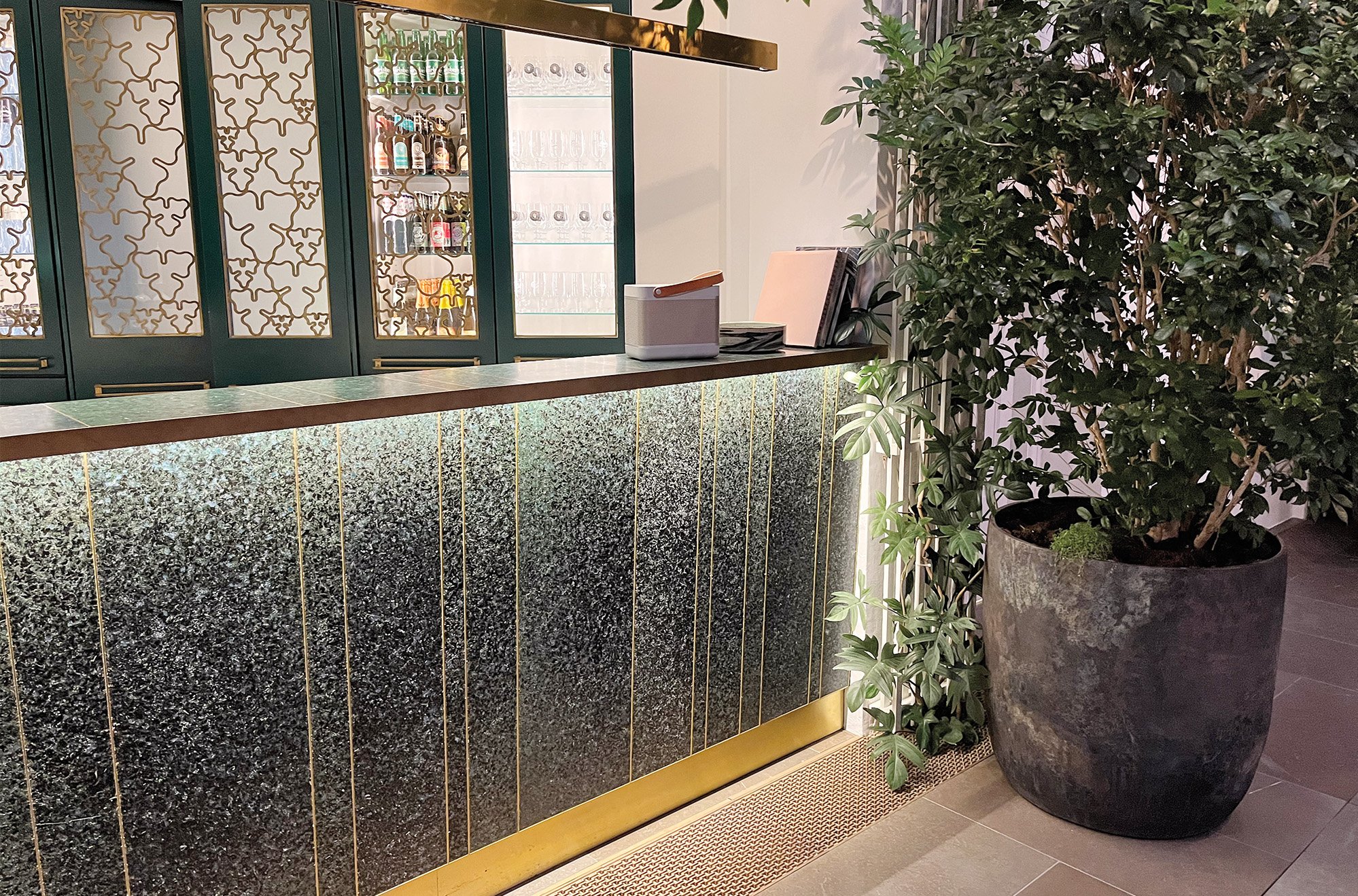 A stone look a like tabletop and front side made from post consumer waste and a large planer kept in front of it. 