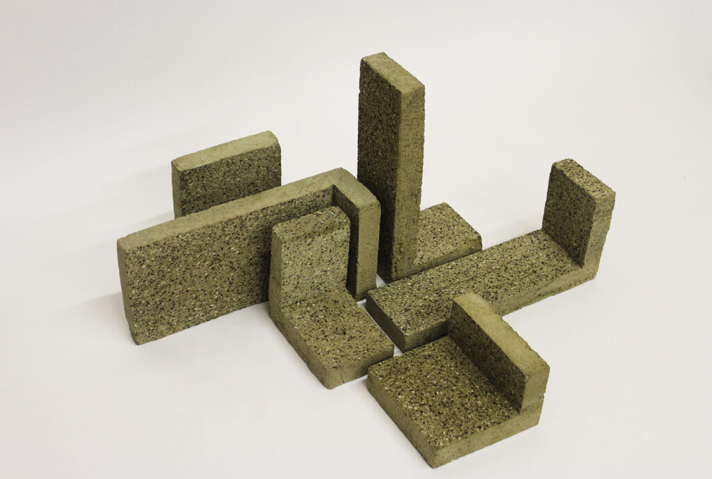 Waste based brick pieces in green kept together in L angles.