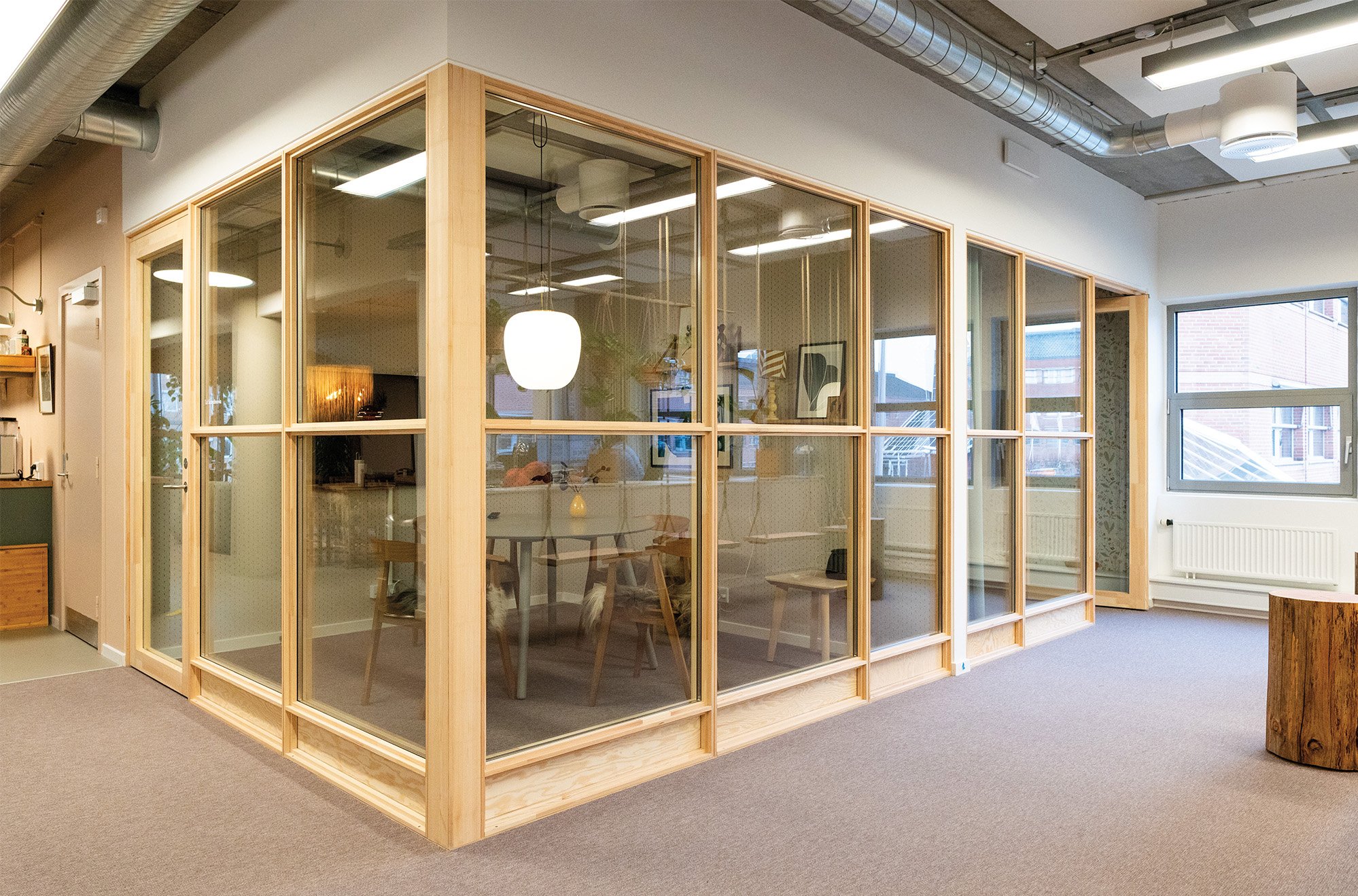 A partitioned conference room made from a waste based material frame and clear glass. 